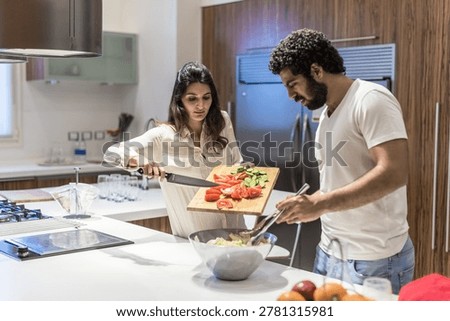 Middle Eastern couple preparing iftar dinner together in modern kitchen for Ramadan and Eid celebration at home