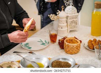 Middle Eastern dining scene with bread, tea, falafel, hummus, olive oil, and juice, capturing traditional Arabic cuisine and warm cultural hospitality.