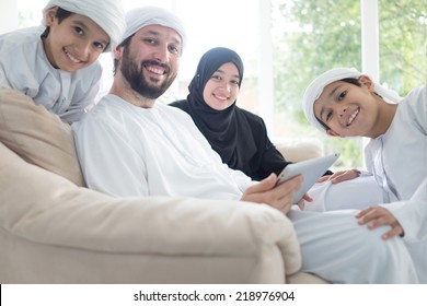 Middle Eastern Family At Home On Couch Using Tablet