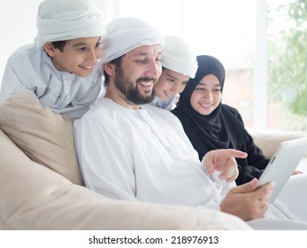 Middle Eastern Family At Home On Couch Using Tablet