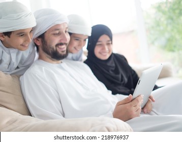 Middle Eastern Family At Home On Couch Using Tablet