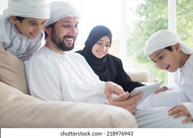 Middle Eastern Family At Home On Couch Using Tablet