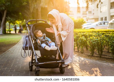 Middle Eastern Family With Traditional Dress Having Fun Outdoors - Modern Islamic Mom And Son In Dubai