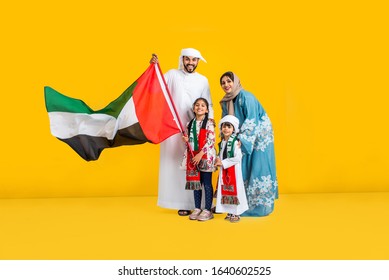 Middle Eastern Family With Traditional Emirates Dresses Posing In A Photographic Studio - Concepts About Lifestyle, Happiness And Family Relationship In The UAE