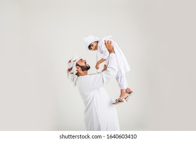 Middle eastern family with traditional emirates dresses posing in a photographic studio - Concepts about lifestyle, happiness and family relationship in the UAE