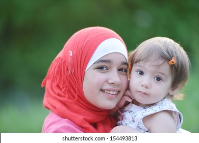 Middle Eastern Female With Little Baby Playing In Summer Grass