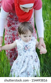 Middle Eastern Female With Little Baby Playing In Summer Grass