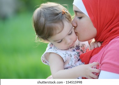 Middle Eastern Female With Little Baby Playing In Summer Grass