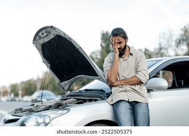 middle eastern Man experiencing car trouble in a parking lot, expressing frustration while standing beside his broken vehicle - Powered by Shutterstock