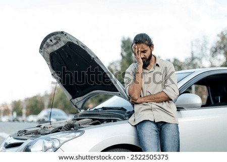 middle eastern Man experiencing car trouble in a parking lot, expressing frustration while standing beside his broken vehicle