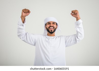 Middle eastern man with traditional emirates dresses posing in a photographic studio - Concepts about lifestyle, happiness and family relationship in the UAE