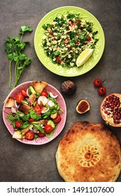 Middle Eastern Salads Tabbouleh And Fattoush, Pitta Bread, Pomegranate, Figs On A Dark Rustic Background. Arabic Dishes, Top View