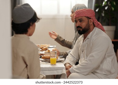 Middle Eastern Uncle Talking To Kid During Family Dinner - Powered by Shutterstock