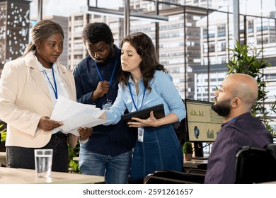 Middle eastern wheelchair user attends a briefing meeting with the team, professional workers discuss about business operations in a disability friendly office. Diverse employees in inclusive space.