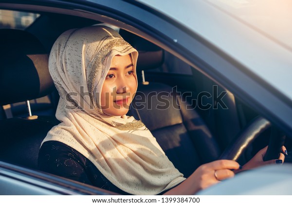 Middle Eastern Woman Driving a Car,\
Looking Forward .Arabic woman in hijab driving a car\
.