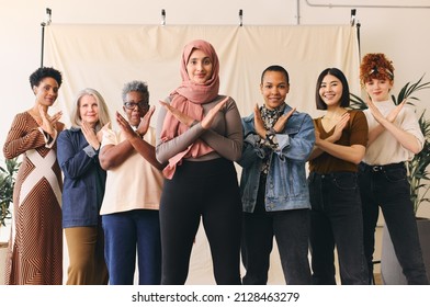 Middle Eastern woman wearing hajib gesturing Break The Bias in support of International Women's Day with female friends - Shutterstock ID 2128463279