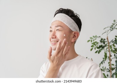 Middle Man Applying Cream To His Face