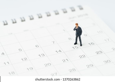 Middle Of Month For Salary Man, Timeline Or Schedule Concept, Miniature People Businessman Office Guy Standing At 15th On Calendar, Looking At The Goal Or Target To Launch The Project Date.