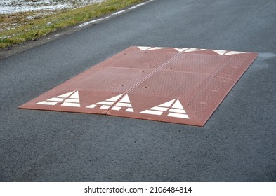 in the middle of the road leading to the residential area, the police and the traffic office installed a red plastic retarder. raised square made of rubber beveled on the sides