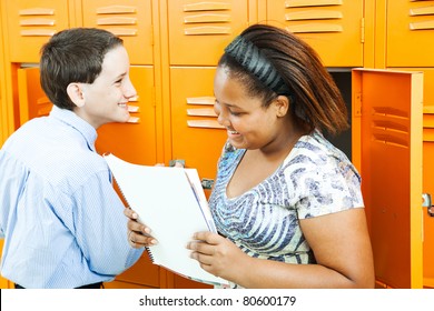 Middle School Boy And Girl Talking Together By The Lockers.