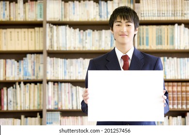 A Middle School Boy Holding A Message Board In A Library