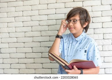 Middle School Boy Student Wearing Glasses On Reading Book For Final Exams Bored And Tired.