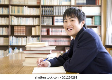 A Middle School Boy Studying In A Library