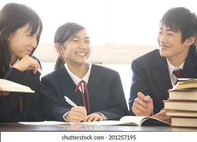 Middle School Boys And Girls Studying In A Library