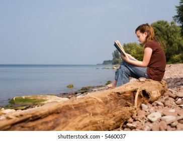 Middle School Girl Reading A Book At The Beach.