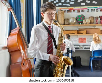 Middle School Student Playing Saxophone In Music Classroom