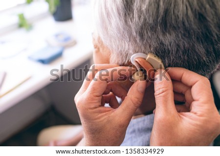 Similar – Image, Stock Photo Woman applying hearing aid to ear