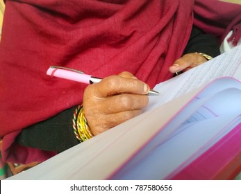 Middle Section Of An Indian Woman Writing On Notebook