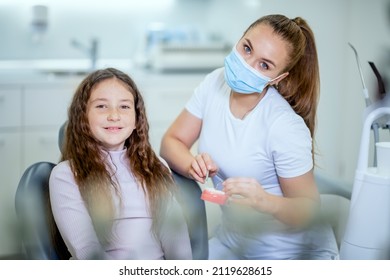 Middle Shot Of Smiling And Satisfied Female Dentist And Girl Child Patient After The Medical Consultation In The Dental Office.