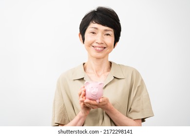 Middle woman laughing with piggy bank - Powered by Shutterstock