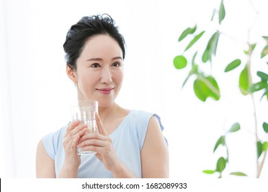 Middle Woman In A Tank Top Drinking Water