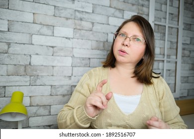 Middle-aged Adult Woman With Glasses Communicates From Home Via Video Link, Gestures With Her Hands, Concept Of Remote Education, Video Conferencing, Lockdown Covid-19