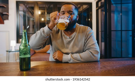 Middle-aged African American male drinking beer having fun happy moment night party event online celebration via video call at home. Social distancing, quarantine for coronavirus. Point of view or POV