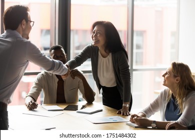Middle-aged asian korean ethnicity businesswoman shake hands with european millennial client. In modern board room group meeting team leaders greeting each other handshaking showing trust and respect - Shutterstock ID 1751484302