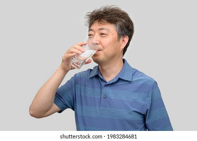 Middle-aged Asian Man Holding A Glass Of Water.