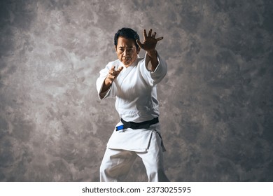 A middle-aged Asian martial artist wearing martial arts uniform. Judoka. Karateka. - Powered by Shutterstock