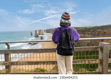 Middle-aged Asian woman backpacking backpacker excitedly arrives at her destination Port Campbell National Park. Great Ocean Road, Victoria State, Australia. - Powered by Shutterstock