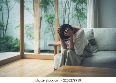 Middle-aged Asian woman in distress - Shutterstock ID 2208279959