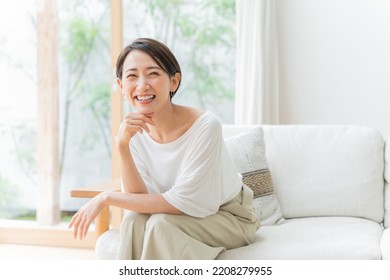 Middle-aged Asian woman relaxing at home