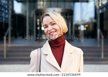 Middle-aged blonde Caucasian woman looking happy to camera. Beautiful mature lady smiling.