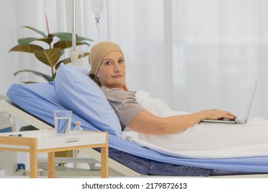 A Middle-aged Breast Cancer Patient Lay On Bed And Still Working With Notebook Computer.