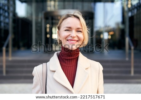 Middle-aged Caucasian businesswoman looking into camera smiles.Beautiful 40-50 years old cheerful lady smiling for the successes of work. High quality photo