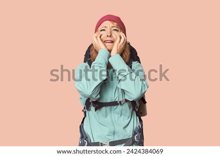 Middle-aged Caucasian woman with hiking gear whining and crying disconsolately.