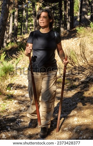 Middle-aged Caucasian woman hiking on Peña Citores peak, using the path of the Alpine Battalion. Sierra de Guadarrama National park, Madrid, Spain.