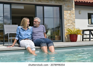 Middle-aged couple enjoying time by private pool - Powered by Shutterstock