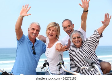 Middle-aged Couple On Bike Ride By The Sea